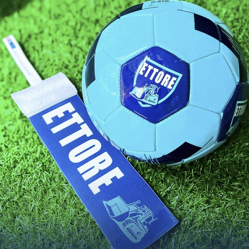 Fascia da capitano e pallone taglia 4 personalizzati colore blu con logo della squadra e una scritta effettuata mediante assistenza reglao, un’idea regalo per il compleanno originale.