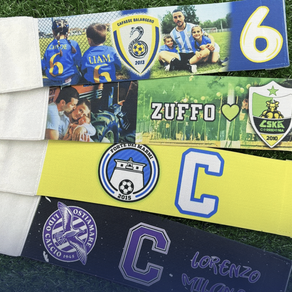 Fascia da capitano e parastinchi personalizzati color rosa con stemma della squadra, un’idea regalo mister calcio utile e originale.
